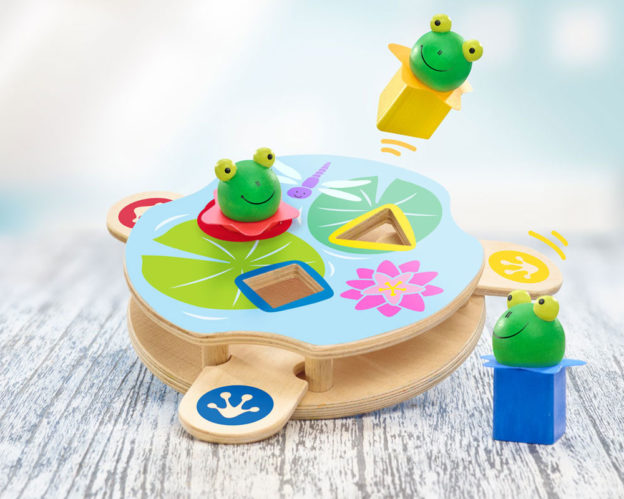 Baby-Holzspielzeug mit lächelnden Froschfiguren und geometrischen Sortierern auf Seerosenblättern, perfekt zum Spielen unterwegs.