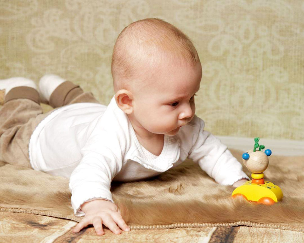 Baby mit Zoolini Giraffe Holzspielzeug von Selecta