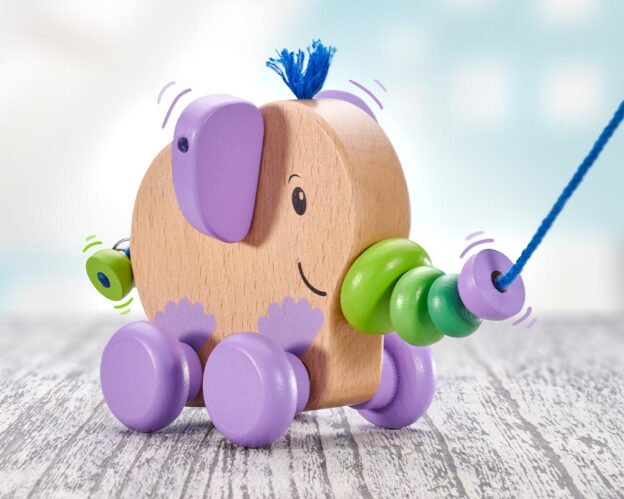 Bunter Nachzieh-Elefant aus Holz mit lila Ohren und Rollen und mit Glocke.