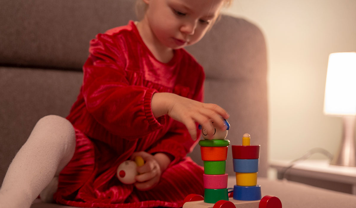 Kleinkind spielt ohne Schnuller mit Steckturm